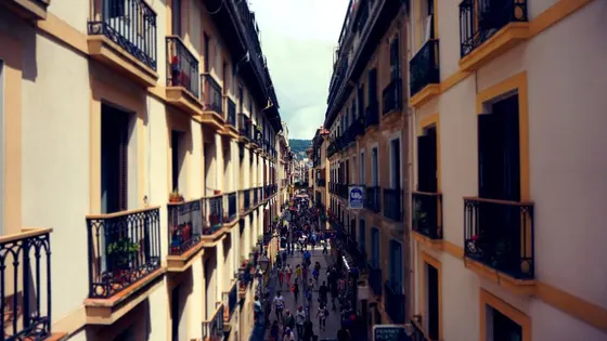 Una calle estrecha con las fachadas y los balcones de los edificios de viviendas a ambos lados.